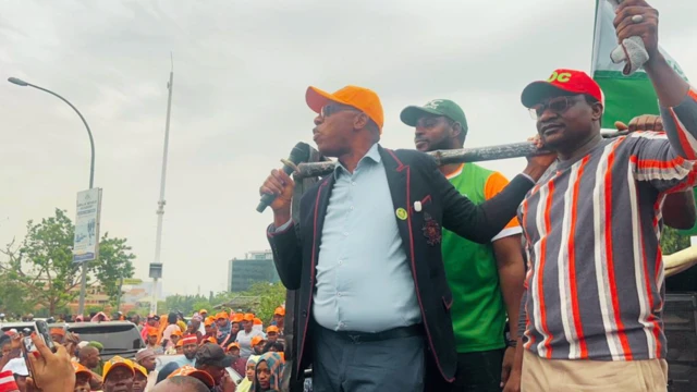 Rotimi Amaechi holding mic wit orange cap, anoda man wit red cap stand beside am