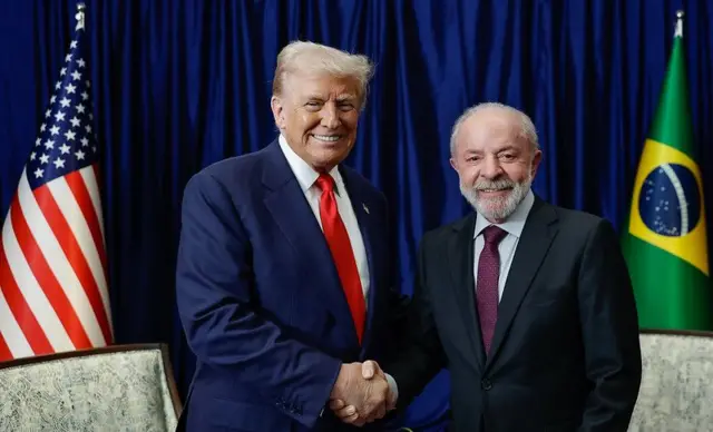 Trump e Lula (à direita) se cumprimentam