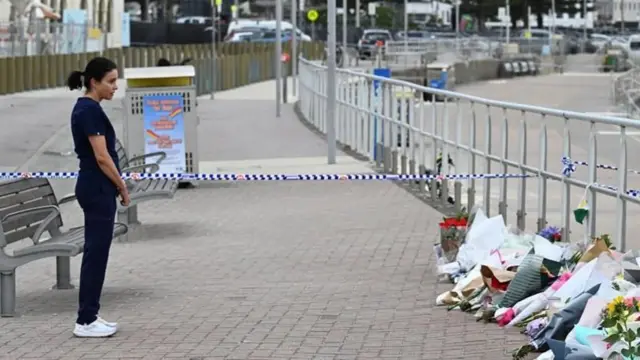 নিহতদের প্রতি শ্রদ্ধা জানাচ্ছেন একজন