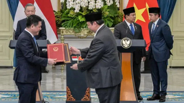 Presiden Prabowo Subianto (kedua dari kanan) berbicara kepada sekretaris kabinetnya Letkol Teddy Indra Wijaya (kanan) sementara Sekretaris Jenderal Partai Komunis Vietnam To Lam (kiri) menyaksikan pertukaran dokumen antara Menteri Koordinator Perekonomian Indonesia Airlangga Hartarto (tengah) dan Menteri Perindustrian dan Perdagangan Vietnam Nguyen Hong Dien (depan, kiri) di Istana Kepresidenan Jakarta pada 10 Maret 2025.
