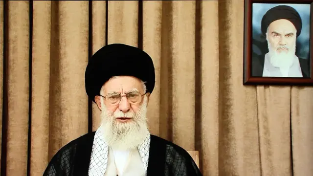 Ayetullah Ali Hamaney, 26 Haziran 2025'te İran'ın ilk dini lideri Ayetullah Ruhullah Humeyni'nin fotoğrafı önüne halka hitap ediyor