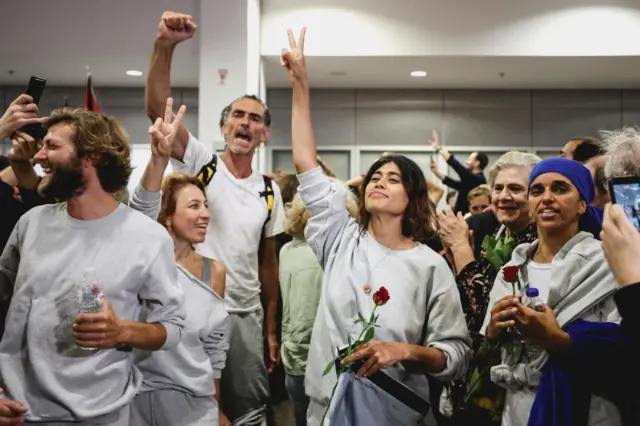 Activistas de la Flotilla Global Sumud saludan mientras reciben ovaciones al llegar a Atenas