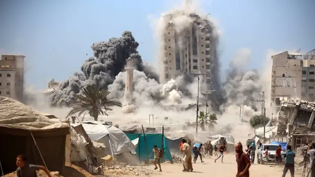 Una torre tras tiendas de campaña es derribada mientras los pobladores huyen