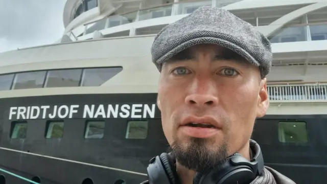 Aleqatsiaq Peary, a 42-year-old Inuit hunter, infront of a boat