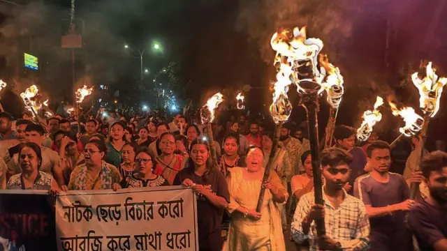 Para profesional medis, aktivis, dan warga Siliguri bernyanyi saat mereka mengambil bagian dalam demonstrasi pada tanggal 14 Agustus 2024 yang diberi nama 'Reclaim the Night', mengutuk pemerkosaan dan pembunuhan seorang tenaga medis muda