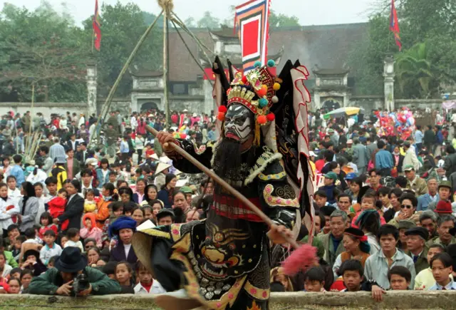 Người dân xem diễn tuồng tại một ngôi đền ở Cổ Loa, ngoại thành Hà Nội vào mùng 6 Tết Canh Thìn