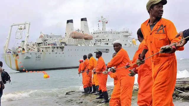Des ouvriers hissent une partie d'un câble de fibre optique sur le rivage dans la ville portuaire kenyane de Mombasa, le 12 juin 2009.