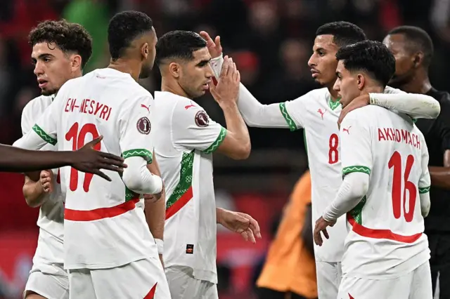 Achraf Hakimi célèbre la victoire avec ses coéquipiers à l'issue du match de phase de groupes de la Coupe d'Afrique des Nations (CAN) opposant la Zambie au Maroc au stade Prince Moulay Abdellah de Rabat, le 29 décembre 2025. 