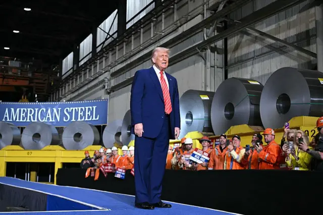 Trump en una planta siderúrgica delante de un cartel que lee 