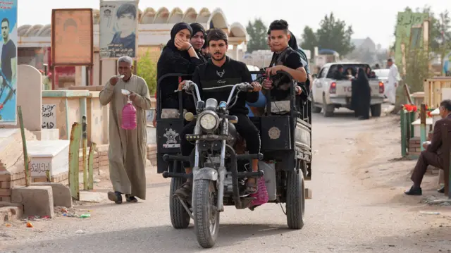 يستقل أشخاص عربة لزيارة قبور أقاربهم في مدينة النجف في العراق