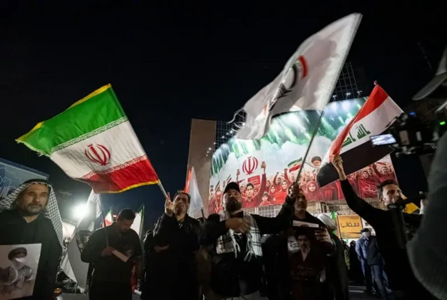 اعضای حشد شعبی عراق در جریان شرکت در تجمعی حامی دولت در مرکز تهران، پرچم‌های حشد شعبی، ایران و عراق را در دست گرفته‌اندند، ۶ آوریل ۲۰۲۶
این تجمع در شرایطی برگزار شد که حمله نظامی آمریکا و اسرائیل در ایران ادامه داشت
