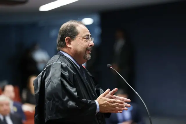 Celso Vilardi usando toga e fazendo a sustentação oral diante de um microfone na Primeira Turma do STF