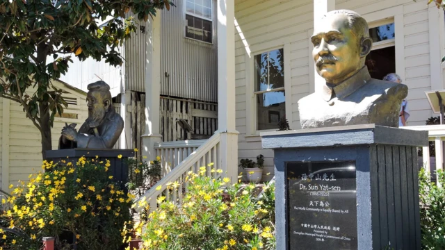 نمای بیرونی یک مدرسه با دو مجسمه در ورودی آن