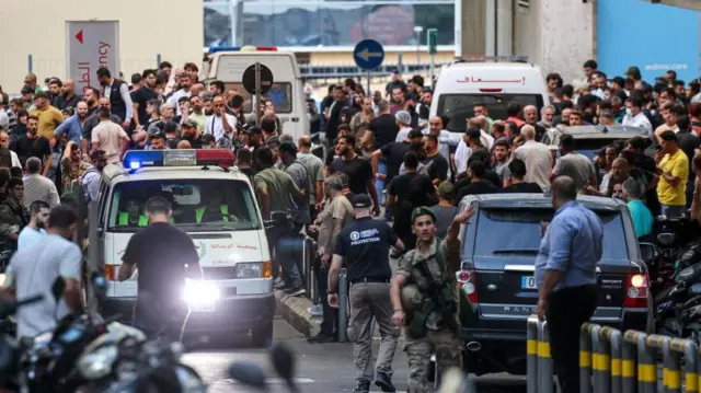 Pessoas aglomeradas na entrada de um hospital em Beirute.

