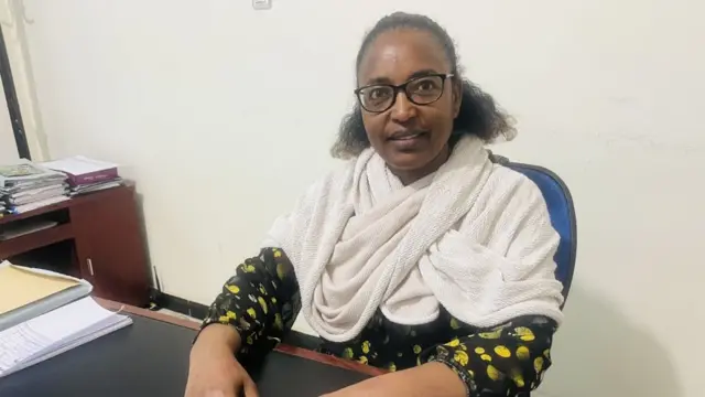 መነጸር-ዓይኒ ዝገበረት፡ ነጸላ ዝለበሰት ወይዘሮ ሃንሳ ተኽላይ ኣብቲ ሰነዳት ዝራኣየሉ ቤት ጽሕፈታ