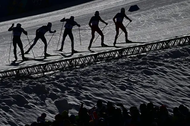 Varios esquiadores, y sus sombras, en una prueba de esquí de fondo en Milán-Cortina 2026