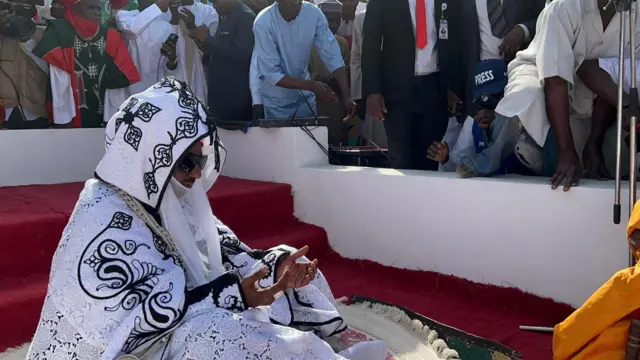 Foto of his royal highness, Emir of Kano, Malam Muhammadu Sanusi Lamido II. E wear black and whir robe wey cover all im body.
