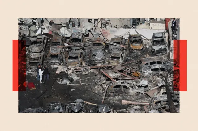 Люди проходять серед уламків автомобілів та будівлі, зруйнованої внаслідок ізраїльського авіаудару, у районі Корніш-ель-Мазраа в Бейруті.