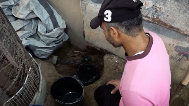 أبو جميل يحاول جمع آخر قطرات الماء