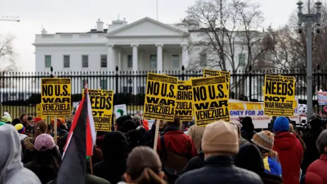 ホワイトハウスの正面のフェンスの前に、毛糸の帽子をかぶるなど防寒着を着た人たちが大勢並んでいる。黄色に黒字のプラカードや、さまざまな横断幕を持った人もいる