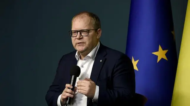 Estoński członek Parlamentu Europejskiego (MEP) Urmas Paet, mężczyzna w okularach w ciemnym garniturze, trzymający mikrofon.