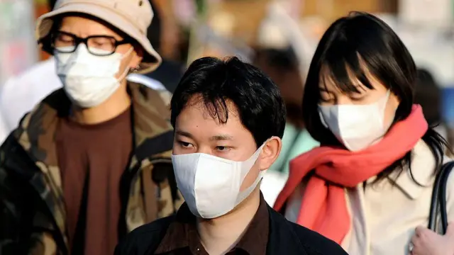 2008年3月15日(星期六),日本东京的行人戴着外科口罩遮盖口鼻