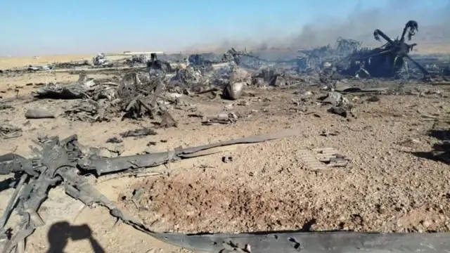 düşen bir uçağın enkazı ve elinde telefon ile görüntü çeken birinin gölgesi