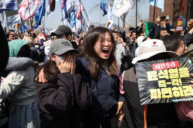People celebrate after President Yoon Suk Yeol's impeachment was accepted, near the Constitutional Court in Seoul, South Korea, April 4, 2025. REUTERS/Kim Hong-ji