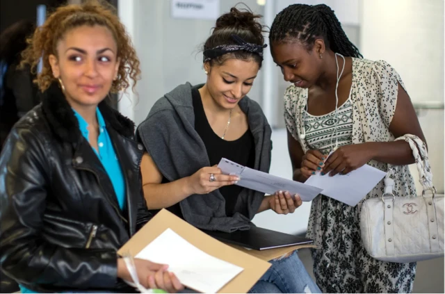 Des adolescentes en train de lire des documents
