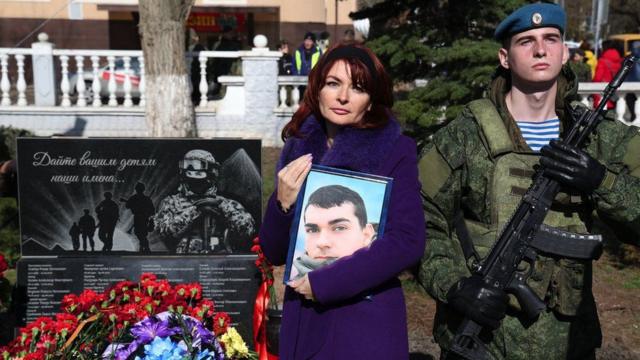 Attendees, including relatives of fallen participants in the Russian military action in Ukraine, take part in a ceremony to honour those killed in the war 