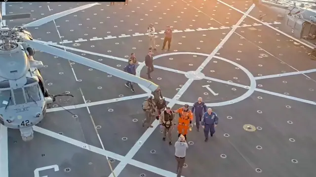 El comandante Reid Wiseman sube a bordo del buque de recuperación tras ser extraído de la cápsula Artemis II por el personal de recuperación en el Océano Pacífico 