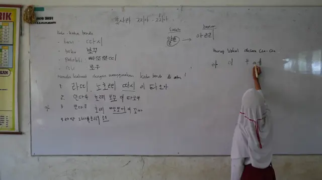 Siswa SDN Karya Baru menulis aksara Hangeul dalam bahasa Cia-Cia di papan tulis.