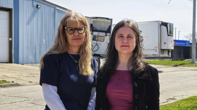 Kathryn Lawton (L) and Christina Grossi stand in front of the Ford plant in Windsor