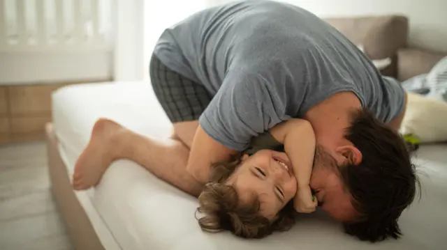 খেলতে খেলতে ছোটো মেয়েকে জাপটে ধরেছে বাবা