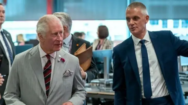 2022 मध्ये किंग चार्ल्स यांना बीबीसी वेल्स ऑफिस दाखवताना टिम डेव्ही 