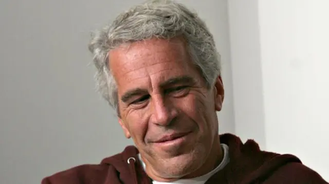 Jeffrey Epstein con un buso vinotinto. 