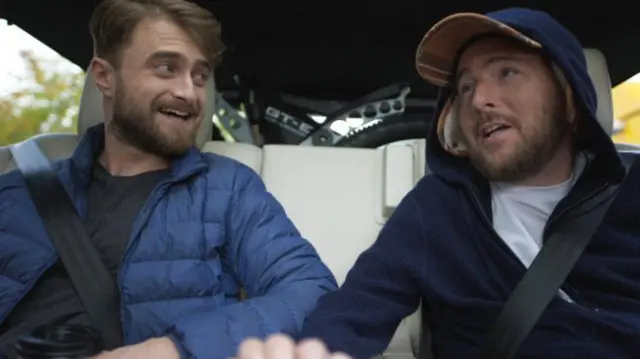 Daniel Radcliffe e David Holmes conversando dentro de carro