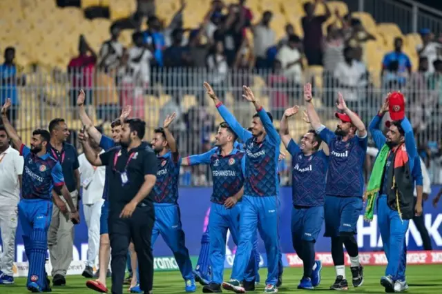 पाकिस्तान को हराने के बाद स्टेडियम में घूमकर दर्शकों का अभिवादन करती अफ़ग़ानिस्तान की क्रिकेट टीम
