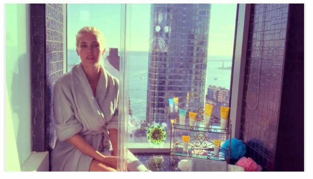 Woman sitting in front of window with city and river in background