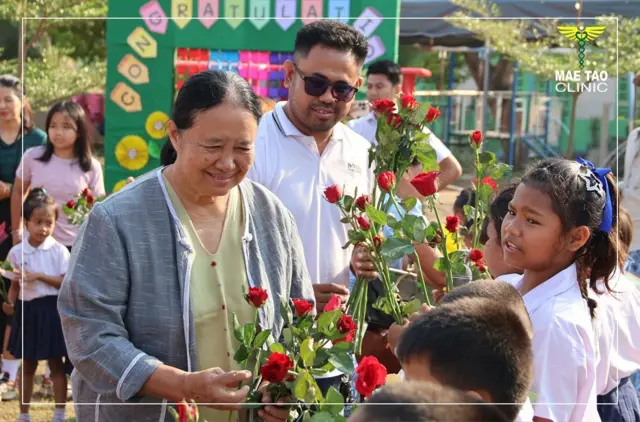 ဒေါက်တာစင်သီယာမောင်ကို ရွေ့ပြောင်းကလေးငယ်တွေကို နှုတ်ဆက်နေတဲ့မြင်ကွင်းအဖြစ် မြင်တွေ့ရ