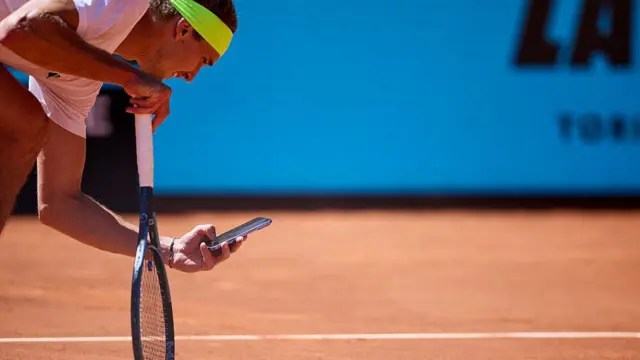 球手亚历山大·兹维列夫（Alexander Zverev）用手机在红土场上拍摄球印