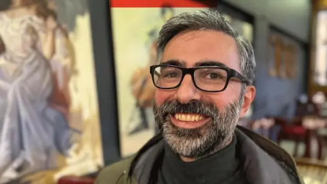 چهره عدی الزوبی که به دوربین نگاه می‌کند و لبخند می‌زند