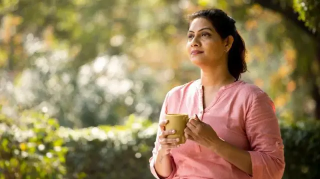ਕੌਫ਼ੀ ਦਾ ਕੱਪ ਫੜ ਕੇ ਖਿਆਲਾਂ ਵਿੱਚ ਗੁਆਚੀ ਔਰਤ