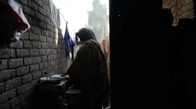 সাহিলের মা নিশা আনসারি চুলার পাশে দাঁড়িয়ে আছেন