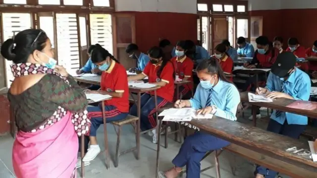 दुई वर्षअघि एसईई परीकामा सहभागी हुँदै केही विद्यार्थी, अगाडि निरीक्षणमा खटेकी एक शिक्षिका उभिएकी छन् 