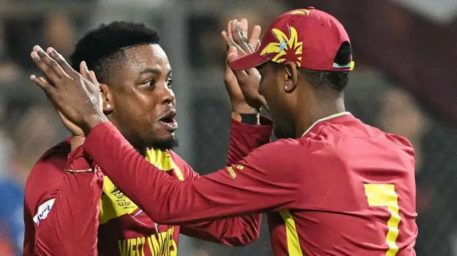 ज़िम्बाब्वे का एक विकेट गिरने के बाद शिमरोन हेटमायर और अकील होसेन जश्न मनाते हुए