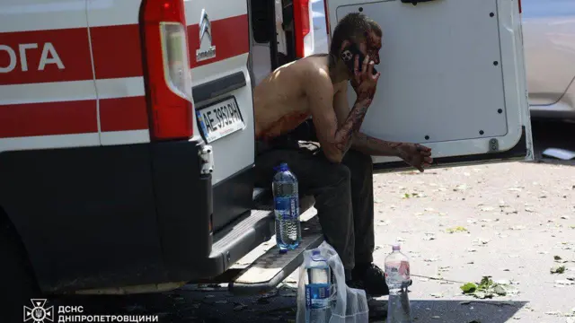 Человек сидит на багажнике машины скорой помози