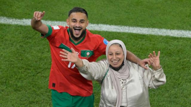 Sesaat setelah Maroko dipastikan mencetak sejarah dengan menjadi tim Afrika pertama yang berhasil menembus semifinal Piala Dunia usai mengalahkan Portugal 1-0, gelandang Sofiane Boufal mengajak ibunya menari di lapangan Stadion Al Thumama, Doha. 
