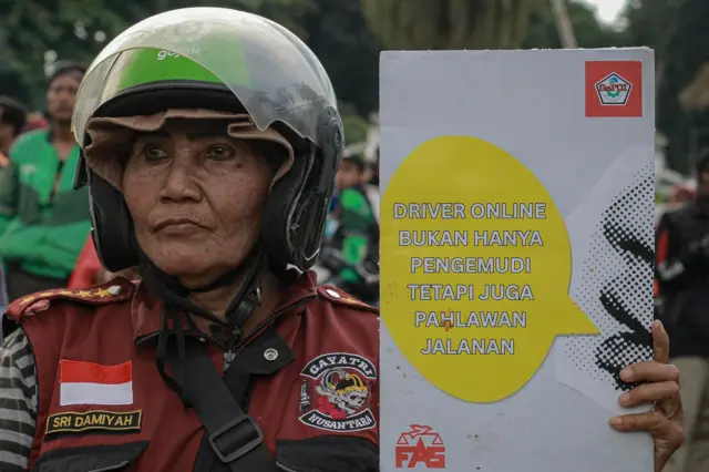 Seorang perempuan pengemudi ojek online terlibat aksi unjuk rasa.