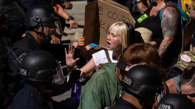Police try to hold back protesters
